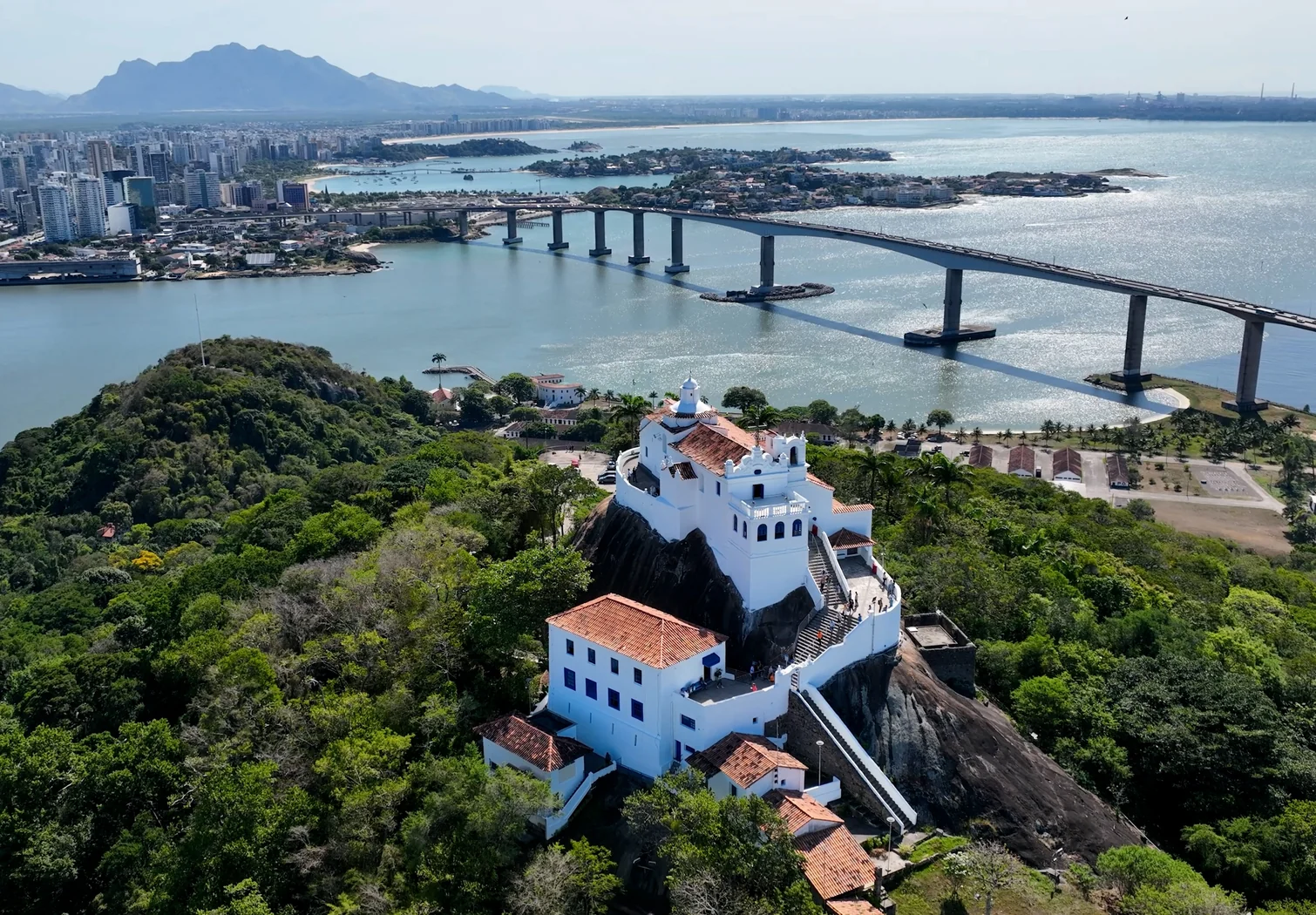 Vista aérea do Convento da Penha em primeiro plano, com a Terceira Ponte e a baía ao fundo